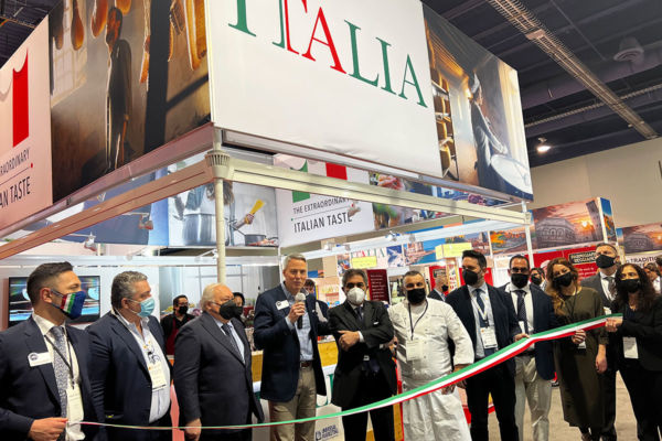 Italian pavilion ribbon cutting at Winter Fancy Food Show. Group of people celebrating Italian food and culture.