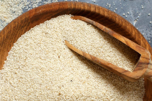 Fonio grains in a wooden bowl with a scoop. Nutritious, affordable, and a vegetable of the future.