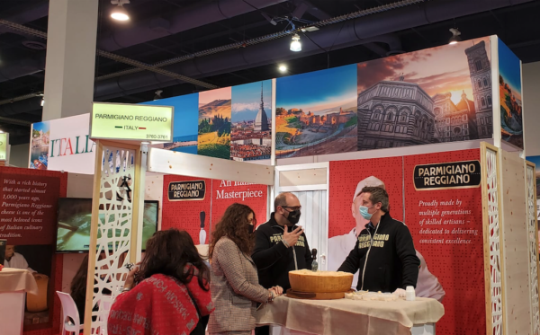 Italian pavilion at Winter Fancy Food Show. Parmigiano Reggiano cheese display with people. Italian food trade show.