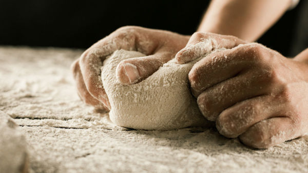 Chef kneading dough with flour. Italian flour for baking bread and pizza.