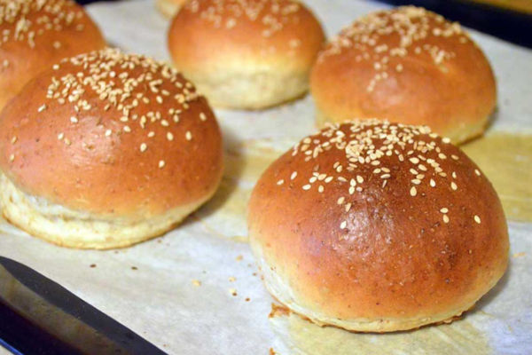 Freshly baked burger buns with sesame seeds. Perfect for sandwiches and rolls.