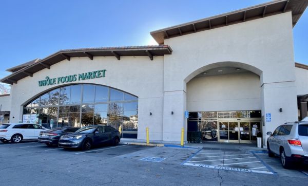 Whole Foods Market in the San Francisco Bay Area. Storefront with parking and blue sky. Italian food shopping.