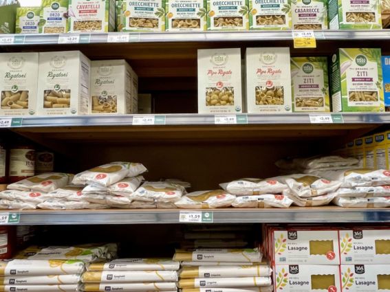 Grocery store shelf with Italian pasta. Boxes of rigatoni, ziti, and bags of spaghetti, lasagna.
