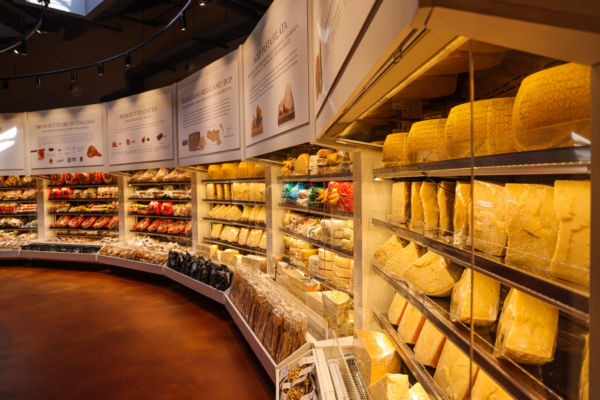 Italian food store with cheese and meat. Retail displays of prosciutto, salami, and parmesan.