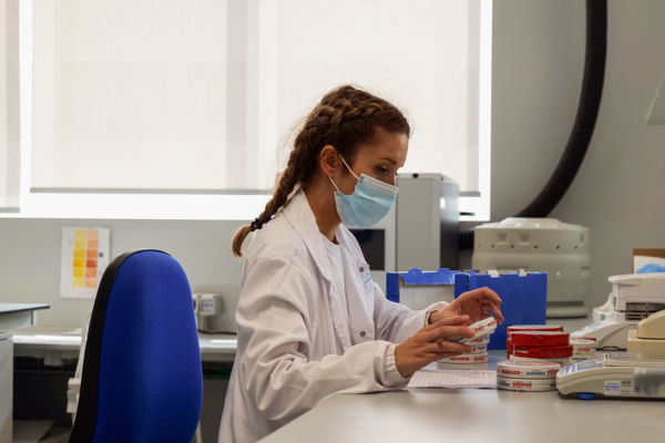 Inalpi lab: Scientist in lab coat and mask examines dairy products. Quality control in Piedmont.