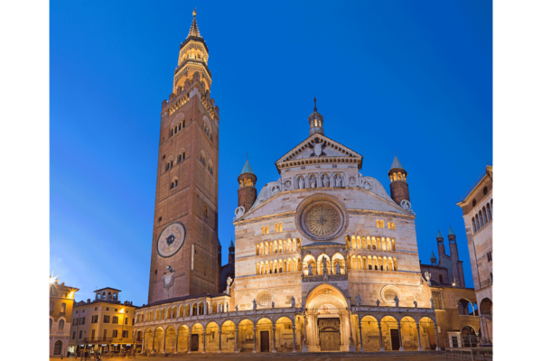 Cremona Cathedral, Lombardy. Italian agrifood region landmark with tower and illuminated facade at dusk.