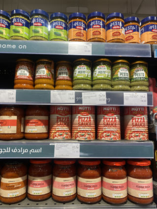 Italian brands Barilla, Mutti, Sacla, Spinneys Food on shelves in Dubai store selling pesto, pizza, tomato sauces.
