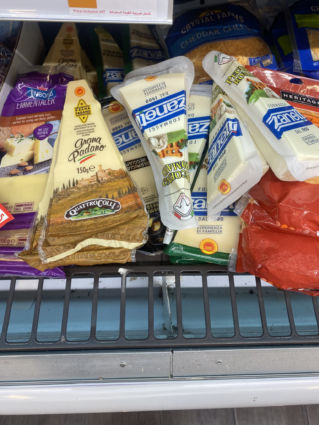 Italian cheeses on Al Maya Supermarket shelf: Grana Padano, Zanetti, Emmentaler, and Crystal Farms Cheddar.
